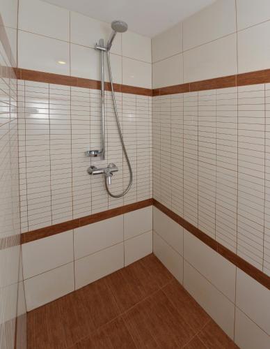 a bathroom with a shower with white tiled walls at Raze in Palanga