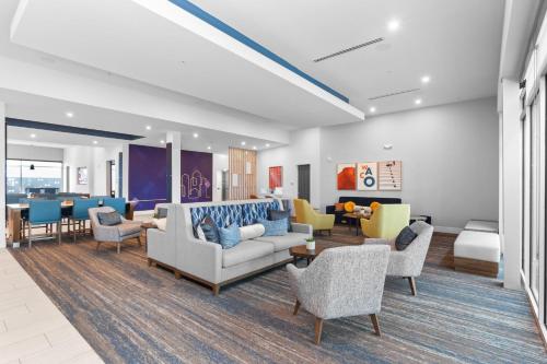 a living room with couches and chairs and a bedroom at Holiday Inn Express & Suites Waco Downtown by IHG in Waco
