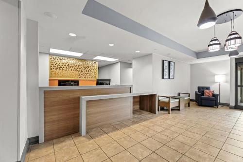 an office lobby with a reception desk and a couch at Candlewood Suites Flowood, MS by IHG in Luckney