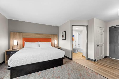a bedroom with a large bed and a bathroom at Candlewood Suites Flowood, MS by IHG in Luckney
