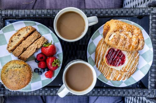 a tray of breakfast food with two cups of coffee and strawberries at Modern Lodge on 6 acres - 15 mins to Camelback in Cresco