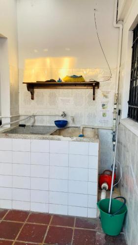 a kitchen with a sink and a bucket on the counter at Casa Vacacional Villavicencio in Villavicencio