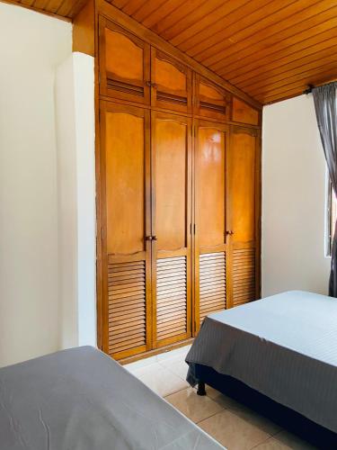 a bedroom with a bed and a wooden cabinet at Casa Vacacional Villavicencio in Villavicencio