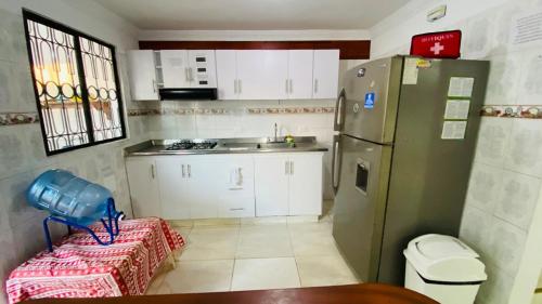 a small kitchen with a refrigerator and a sink at Casa Vacacional Villavicencio in Villavicencio