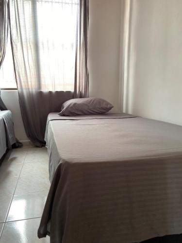 a bed in a room with a window at Casa Vacacional Villavicencio in Villavicencio