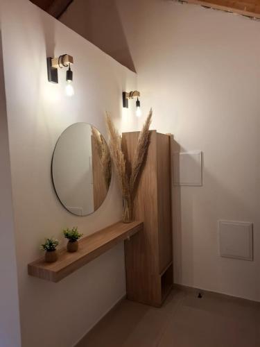 a bathroom with a round mirror on the wall at סוויטות אוצר המעיינות in Reẖov