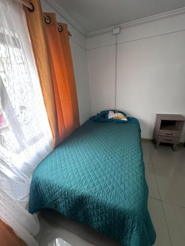 a small bed in a room with a window at Casa Miraflores in Tocopilla