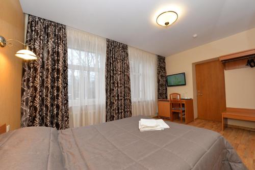 a bedroom with a bed and a large window at Raze in Palanga