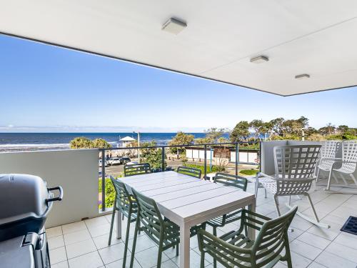 a table and chairs on a balcony with a view of the ocean at Beaches on Maroochy 1 Beach Parade in Maroochydore