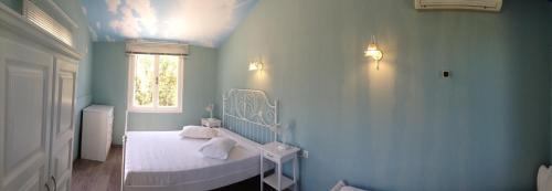 a blue bedroom with a bed and a window at Sea Sun in Plomarion