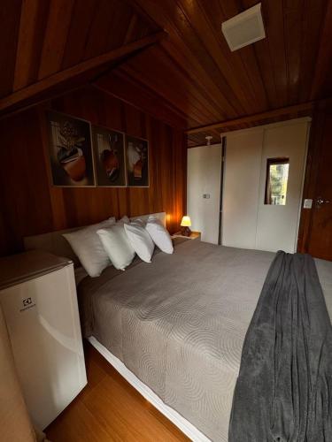 a bedroom with a large bed in a room at Pousada Araucária Suítes in Campos do Jordão