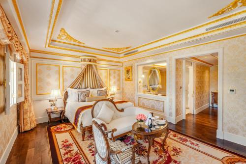 a bedroom with a bed and a couch and a table at Dalat Palace Heritage Hotel in Da Lat