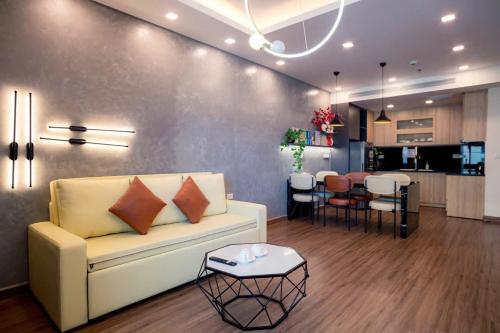归仁FLC Sea Tower QUY NHƠN-Khách Sạn 5 Sao-Hồ Bơi-View Biển-Trung Tâm Tp的客厅里有一张白色的沙发和一张桌子