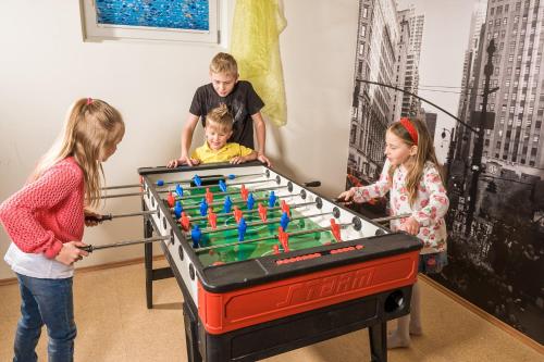 a group of children playing with a foosball table at GRUBERS, Hotel Appartments Gastein in Bad Gastein