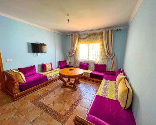 a living room with purple couches and a table at Visit Chamal - Solaya in Oued Laou
