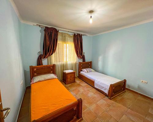 two beds in a room with blue walls at Visit Chamal - Solaya in Oued Laou