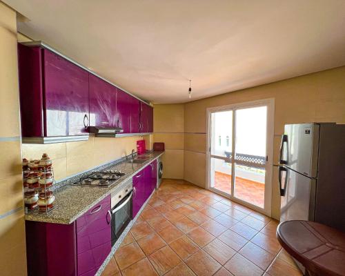 a kitchen with purple cabinets and a refrigerator at Visit Chamal - Solaya in Oued Laou
