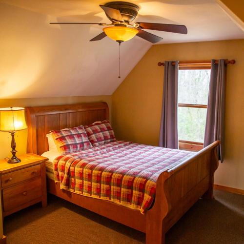 a bedroom with a bed with a ceiling fan and a window at Hawks Peak - by The Chalets in Logan