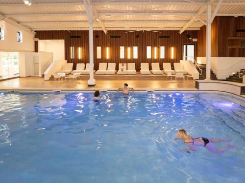 a group of people swimming in a large swimming pool at Les Folies d 'Oscar in Châtellerault