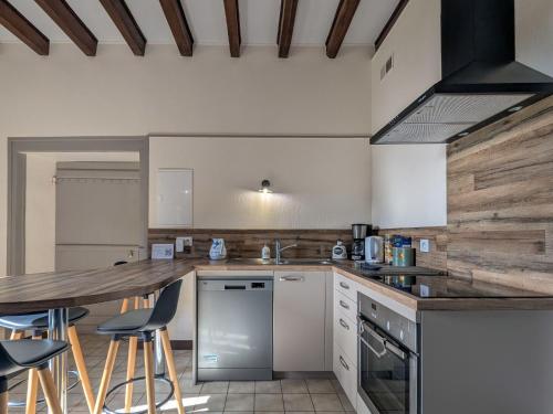 une cuisine avec un comptoir et des tabourets. dans l'établissement Gîte à la ferme avec jardin privatif, proche de sites touristiques et tout confort inclus - FR-1-591-341, à Cluis