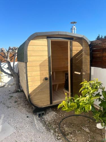 a small wooden hobbit house sitting next to a building at Villa Kala Loutraki - Private Pool & Sauna I Beach in Loutraki