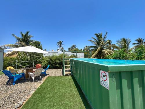 a backyard with a pool and a table and chairs at Yellow house 6 minutos de playa in Barra de Navidad