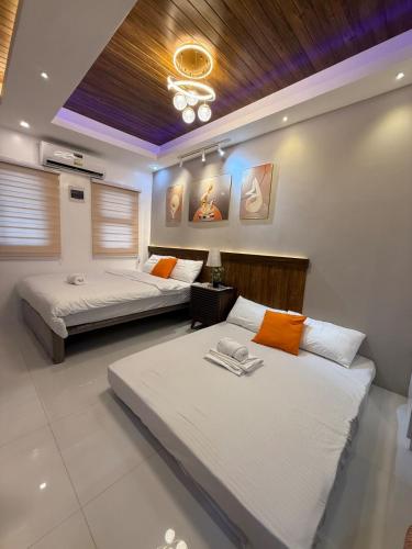 a bedroom with two beds and a couch at DJS Home Studio Gensan Netflix,free wifi,hot&cold shower,near Airport in General Santos