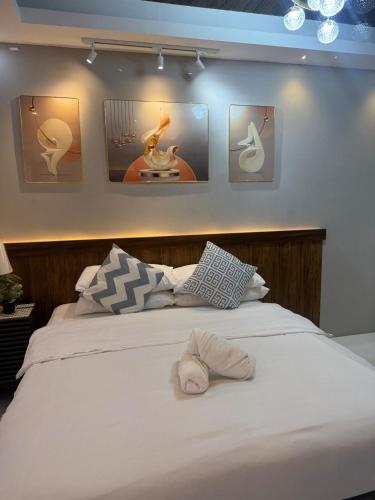 a bedroom with a white bed with pictures on the wall at DJS Home Studio Gensan Netflix,free wifi,hot&cold shower,near Airport in General Santos
