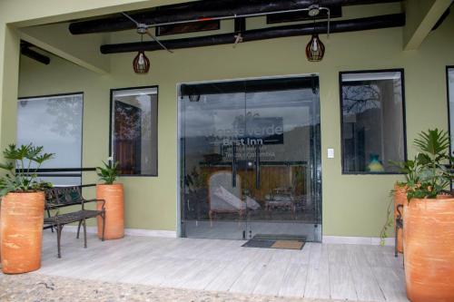 a store front with a bench and a glass door at Monteverde Best Inn - HOTEL in Tenza