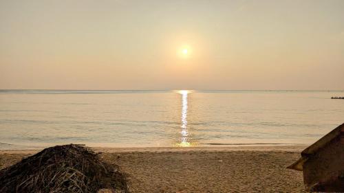 a beach with the sun setting over the water at Dutch Villa - Trincomalee in Trincomalee