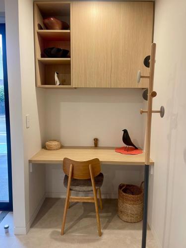 a desk with a chair and a bird sitting on it at Better than the rest - Central City Luxury in Christchurch
