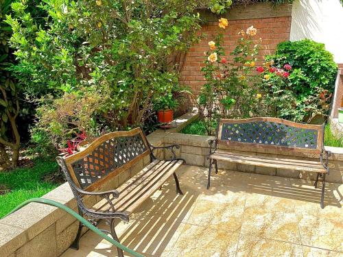 two benches sitting next to each other in a garden at Casa de Campo en Santa Eulalia in Santa Eulalia