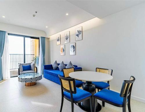 a living room with a blue couch and a table and chairs at Hillside apartment sunset town city in Phu Quoc