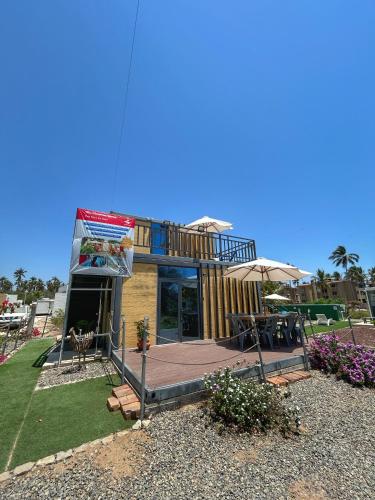 a small house with a deck and a patio at Yellow house 6 minutos de playa in Barra de Navidad