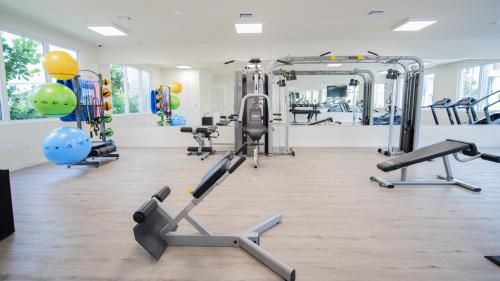 a gym with several tread machines and a mirror at Beachside Bliss, 1BR Condo with Pool at Dania Beach in Dania Beach