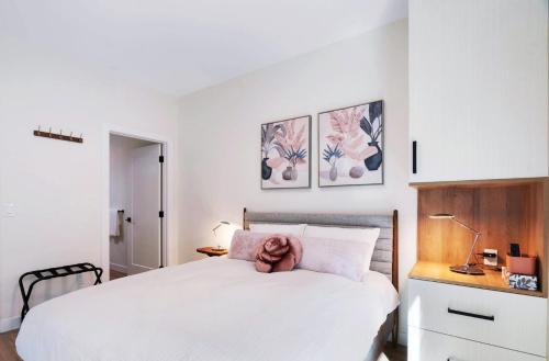 a bedroom with a white bed with a teddy bear on it at Raven's Peak 105 - Ultra luxe Mountain Retreat in Canmore