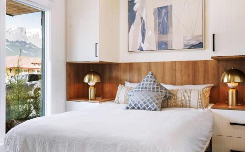 a bedroom with a white bed and a window at Raven's Peak 105 - Ultra luxe Mountain Retreat in Canmore