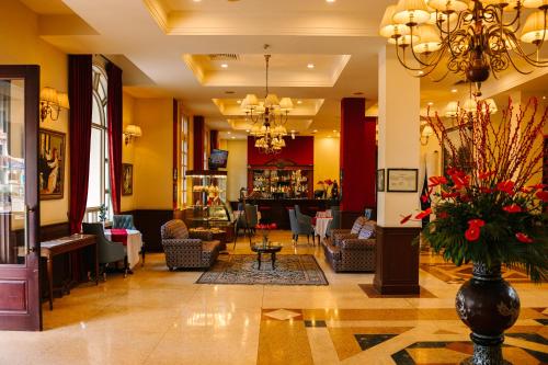 a lobby with a waiting area with chairs and a vase with flowers at Du Parc Hotel Dalat in Da Lat