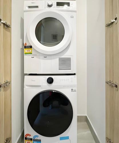 a dryer with a microwave and a washing machine at 2BR City Townhouse with air con Courtyard and Parking in Auckland