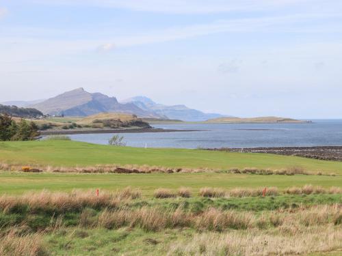 a golf course with a lake and mountains in the background at Tigh na Creag in Sconser