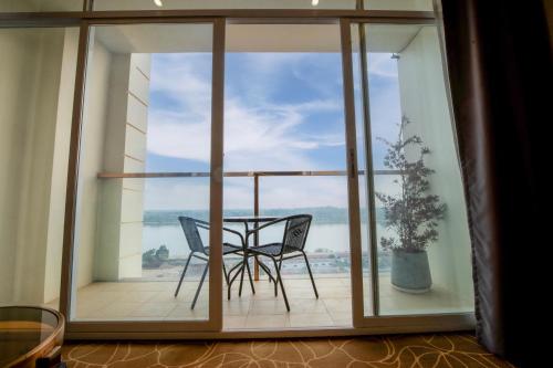 a balcony with a table and chairs and a window at ST Hotel Wattay Airport in Vientiane