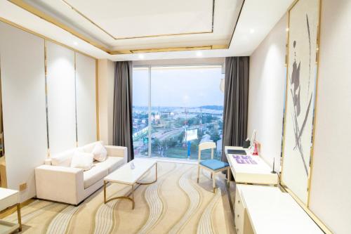 a living room with a white couch and a large window at ST Hotel Wattay Airport in Vientiane