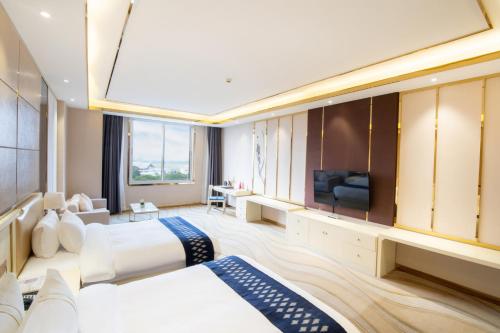 a hotel room with two beds and a television at ST Hotel Wattay Airport in Vientiane