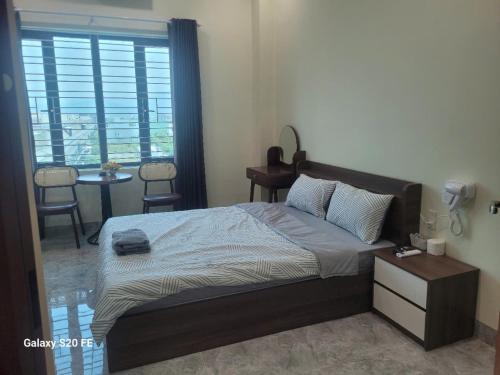 a bedroom with a bed and a table and a window at Kiều Trang Homestay Đà Nẵng in Da Nang