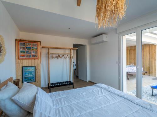 a bedroom with a bed and a large window at Appartement T3 PMR Biscarrosse 6 Pers, Clim Parking - FR-1-319-607 in Biscarrosse