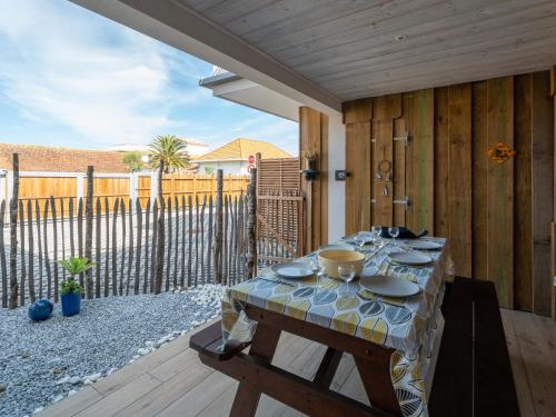 - une table avec des assiettes et des bols sur une terrasse dans l'établissement Appartement T3 proche océan, Biscarrosse Plage, pour 6, parking - FR-1-319-606, à Biscarrosse