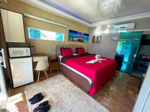 a bedroom with a bed with a white dog on it at Pousada Papito Ubatuba - Praia Perequê-Açu in Ubatuba