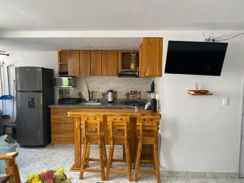 uma cozinha com mesas de madeira e um frigorífico em Acojedor apto en coveñas em Coveñas