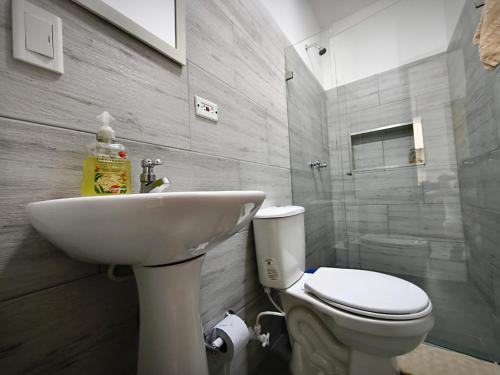 a bathroom with a white toilet and a sink at Apartamento nuevo en primer piso in Jardin