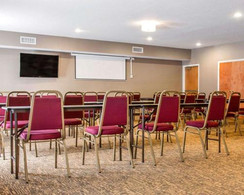a conference room with tables and chairs and a screen at Comfort Suites Benton Harbor - St Joseph in Benton Harbor
